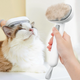 Person using a pet grooming brush on a cat