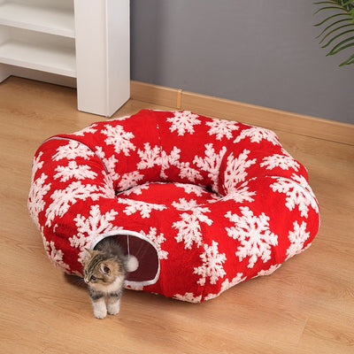 Red snowflake cat tunnel bed with kitten walking out of the tunnel opening