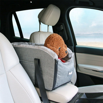 Pet car seat cover in a car with a small dog inside, beach visible through window
