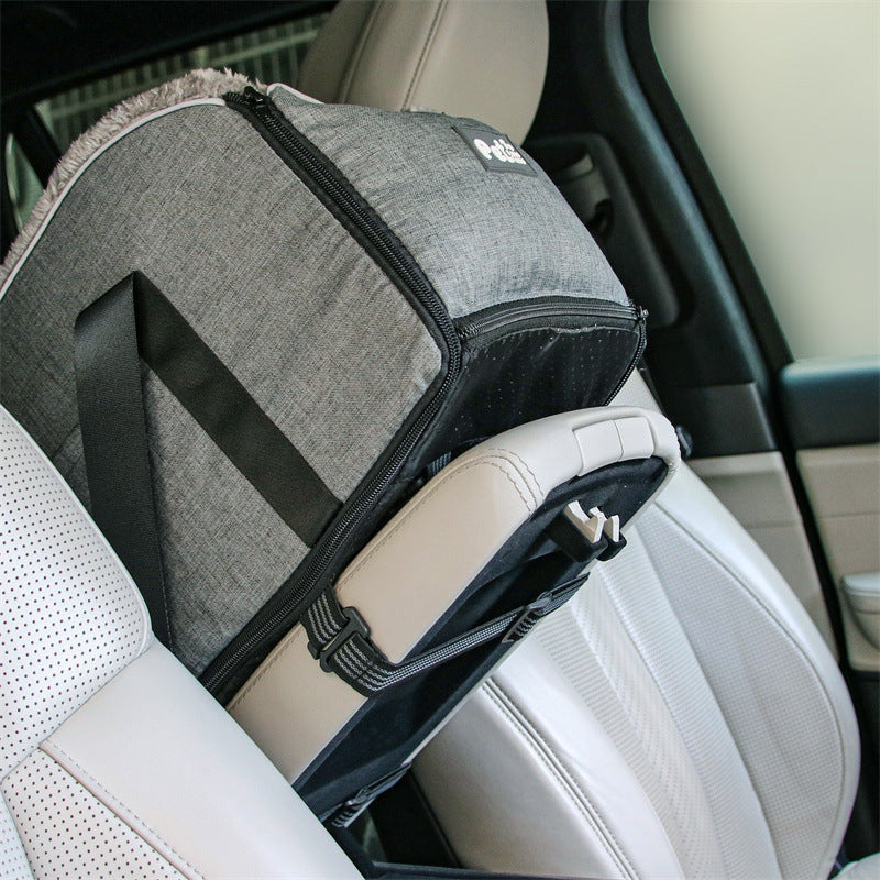 Gray pet carrier attached to a car seat with a visible brand logo.
